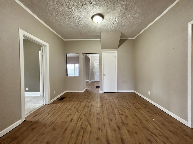 unfurnished bedroom featuring hardwood / wood-style flooring, crown molding, and a textured ceiling