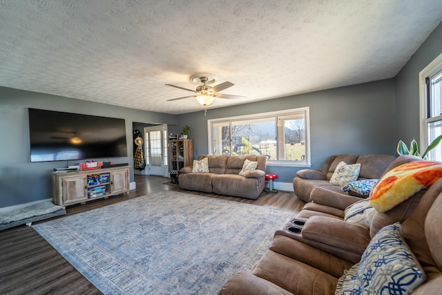 living room featuring ceiling fan, hardwood / wood-style floors, and a textured ceiling