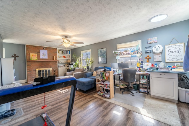 office space with built in features, hardwood / wood-style floors, a textured ceiling, and a fireplace