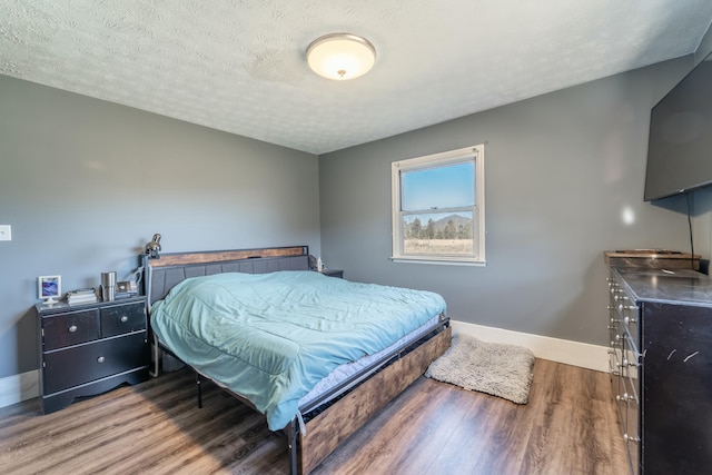 bedroom featuring wood-type flooring and a textured ceiling