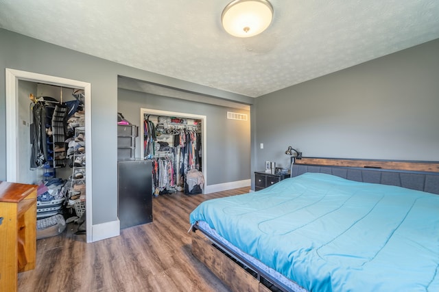 bedroom with dark hardwood / wood-style flooring and a textured ceiling