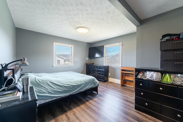 bedroom with dark wood-type flooring and a textured ceiling