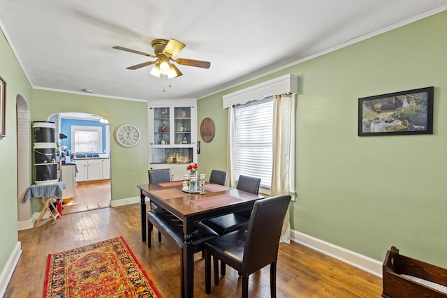 dining area featuring crown molding, ceiling fan, hardwood / wood-style flooring, and a healthy amount of sunlight