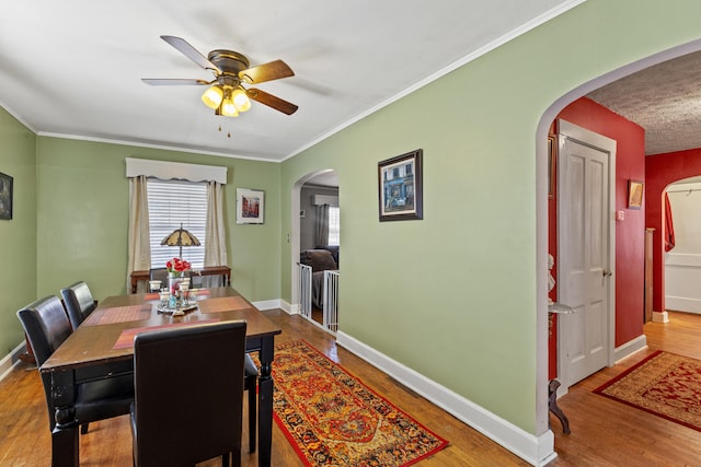 dining space with wood-type flooring and ornamental molding