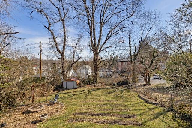 view of yard with an outdoor fire pit and a shed