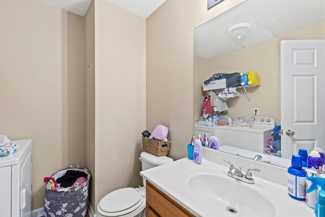 bathroom featuring vanity, independent washer and dryer, and toilet