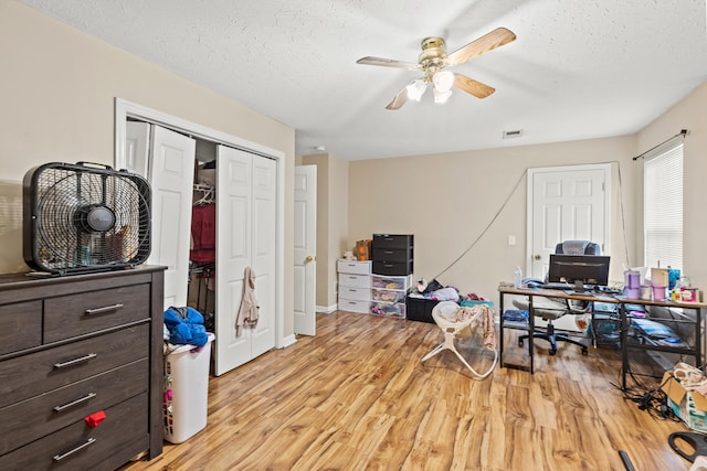 office space with ceiling fan, a textured ceiling, and light hardwood / wood-style floors