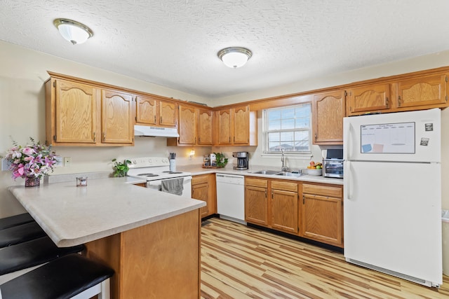 kitchen featuring sink, white appliances, light hardwood / wood-style floors, kitchen peninsula, and a textured ceiling