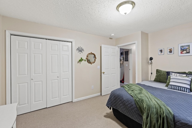 carpeted bedroom featuring a textured ceiling and a closet