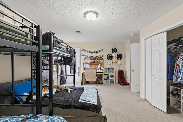 carpeted bedroom featuring a textured ceiling and a closet