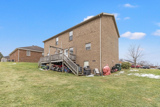 rear view of house featuring a wooden deck and a yard