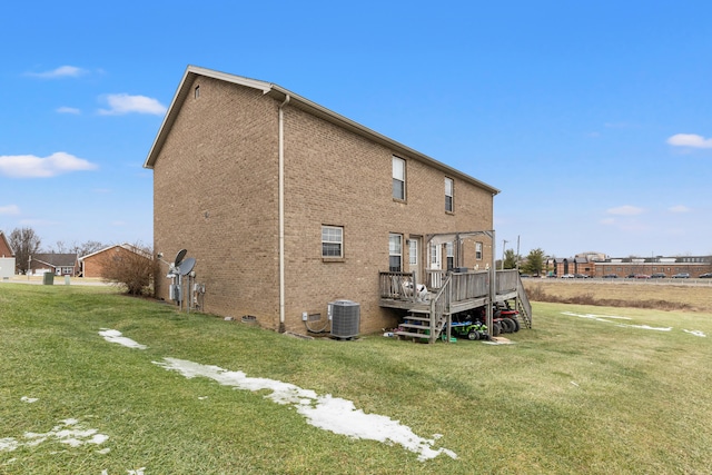 back of property featuring a wooden deck, cooling unit, and a lawn