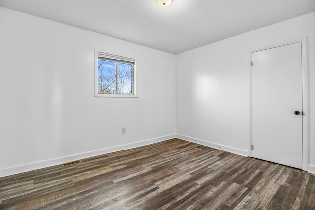 spare room featuring dark wood-type flooring