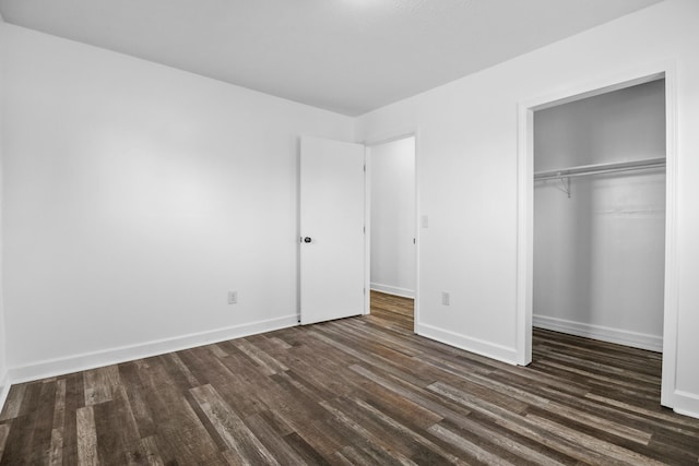 unfurnished bedroom featuring dark hardwood / wood-style flooring and a closet