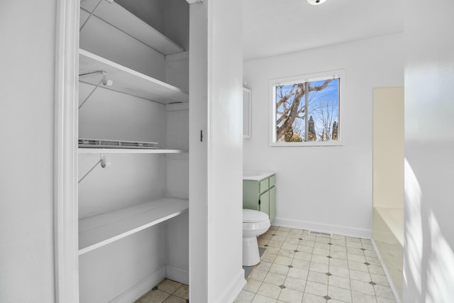 bathroom with vanity, a bathing tub, and toilet