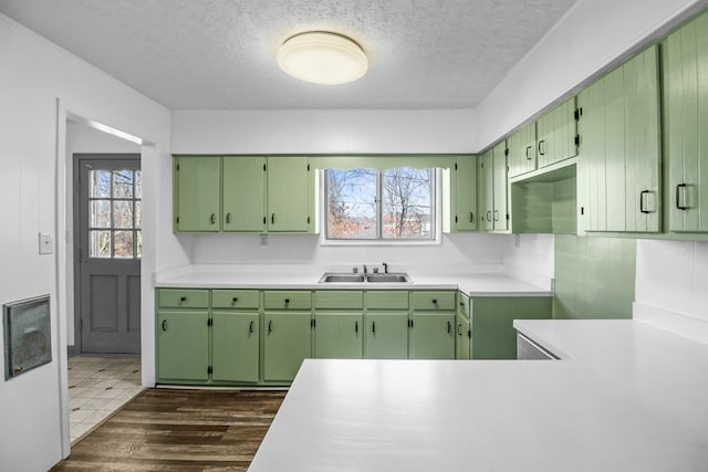 kitchen with dark wood-type flooring, sink, green cabinets, and a wealth of natural light