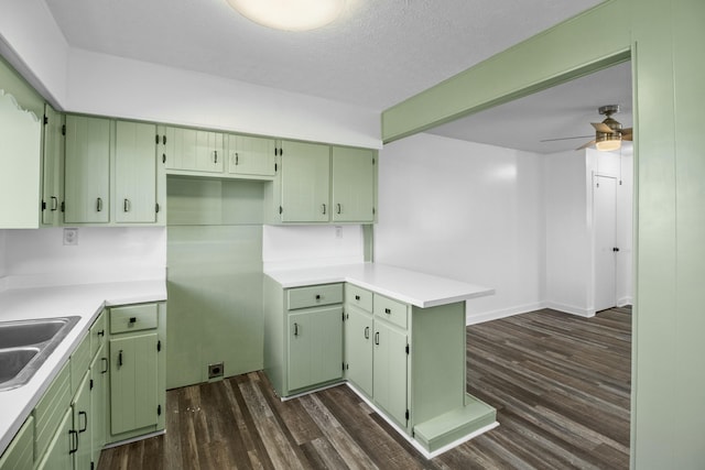 kitchen featuring dark hardwood / wood-style flooring, kitchen peninsula, and green cabinets