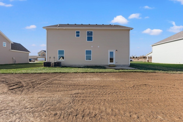 rear view of house featuring a yard and central air condition unit