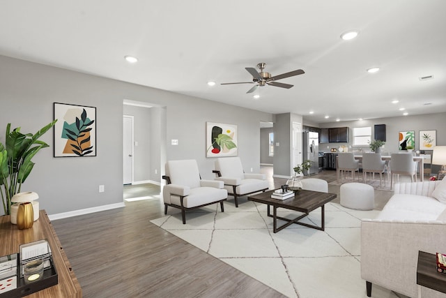 living room with ceiling fan and light hardwood / wood-style floors