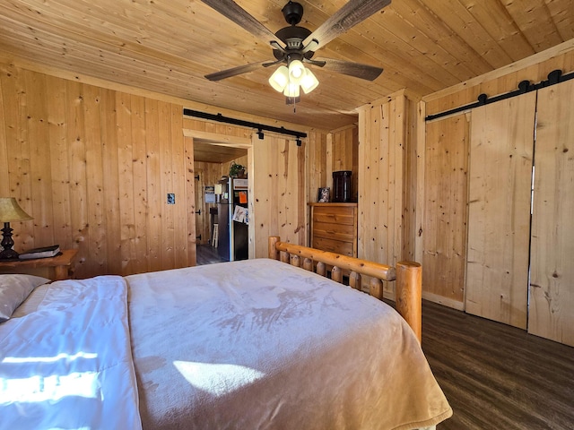 bedroom featuring dark hardwood / wood-style flooring, a barn door, wood ceiling, and wood walls