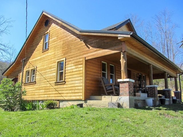 view of property exterior featuring covered porch and a lawn