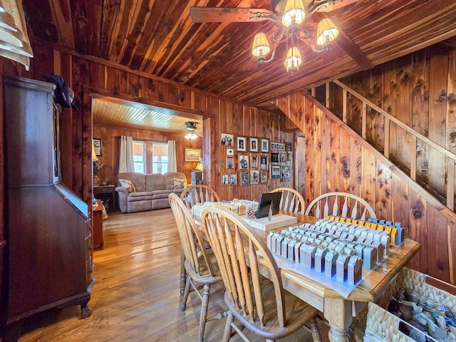 dining room with ceiling fan, light hardwood / wood-style floors, wood walls, and wooden ceiling