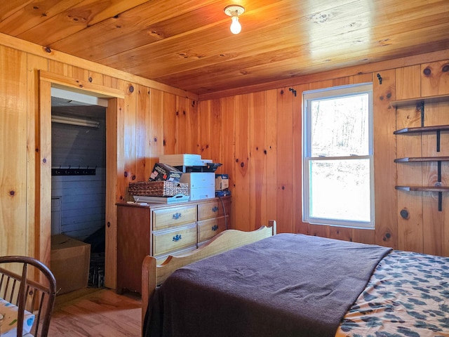 bedroom with light wood-type flooring, wood ceiling, and wood walls