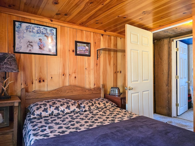 carpeted bedroom with wooden ceiling and wood walls