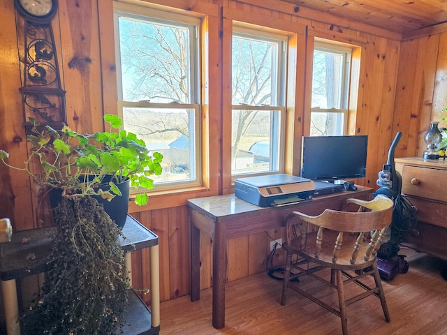 office with hardwood / wood-style flooring, wooden walls, and a healthy amount of sunlight