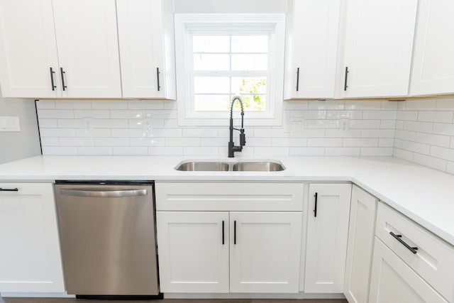 kitchen with backsplash, stainless steel dishwasher, sink, and white cabinets