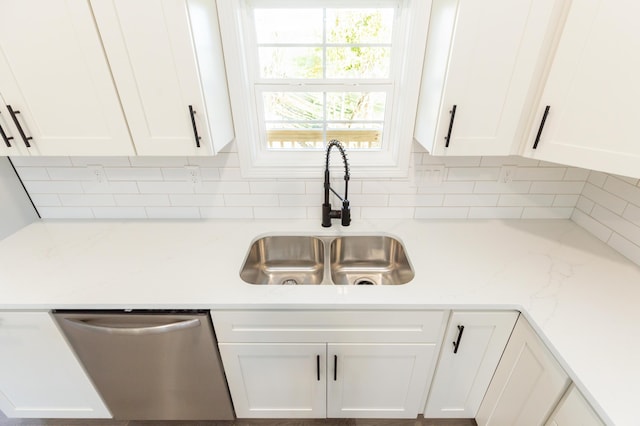 room details with white cabinetry, sink, tasteful backsplash, and stainless steel dishwasher