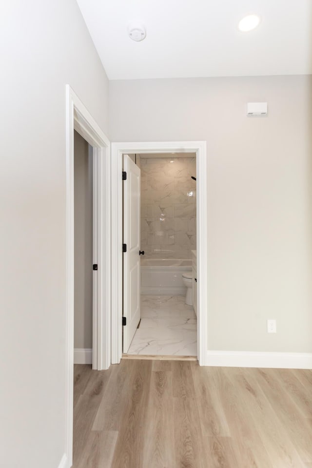 hallway with light hardwood / wood-style floors