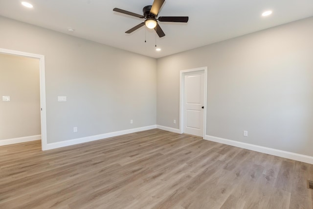 empty room with ceiling fan and light hardwood / wood-style floors