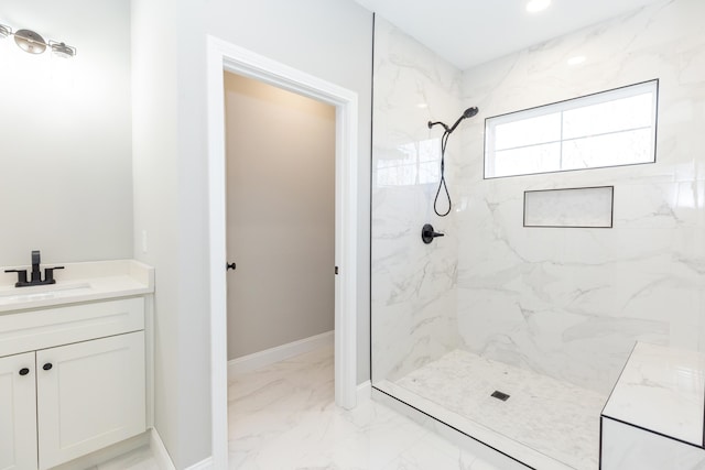 bathroom featuring tiled shower and vanity