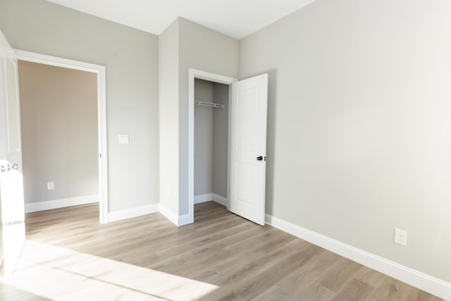 unfurnished bedroom featuring light wood-type flooring and a closet