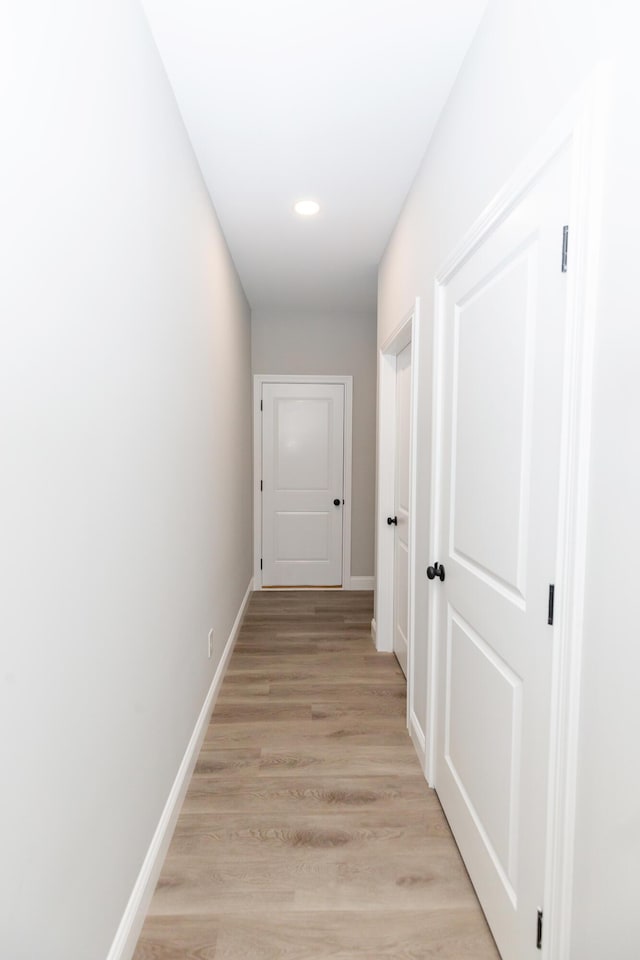 hallway with light hardwood / wood-style floors