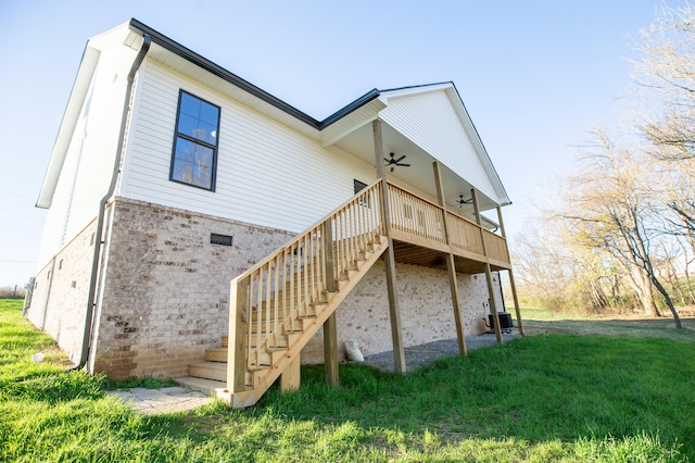 rear view of property with a wooden deck, a yard, central AC, and ceiling fan