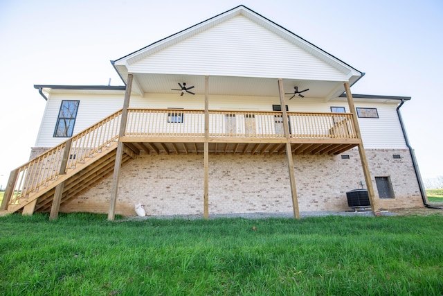 rear view of house with central AC, a deck, ceiling fan, and a lawn