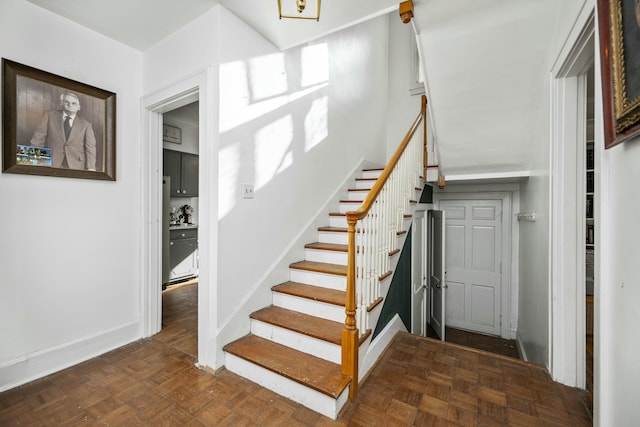 staircase featuring baseboards