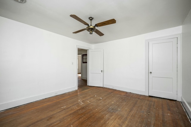 unfurnished bedroom with a ceiling fan, dark wood-style flooring, and baseboards