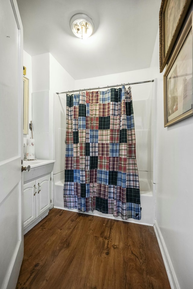 full bath featuring shower / bath combination with curtain, vanity, baseboards, and wood finished floors