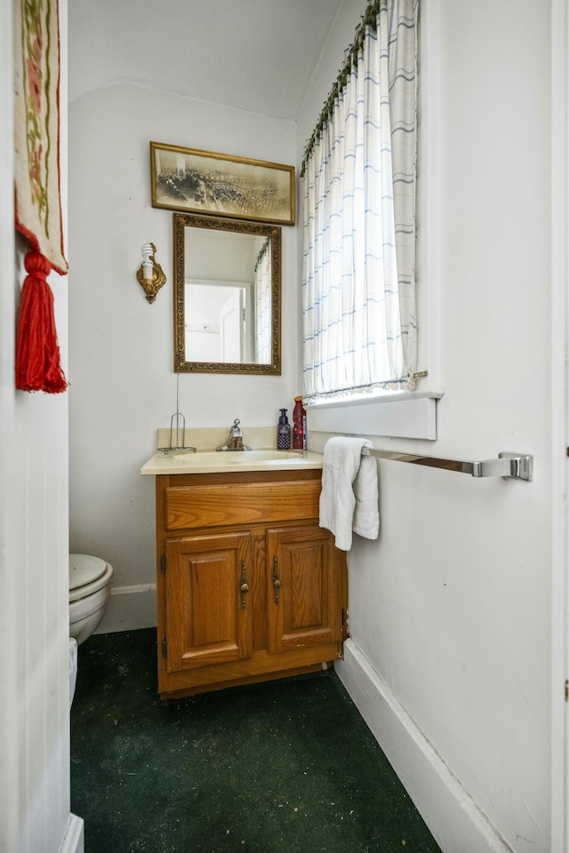 bathroom with vanity, toilet, and baseboards