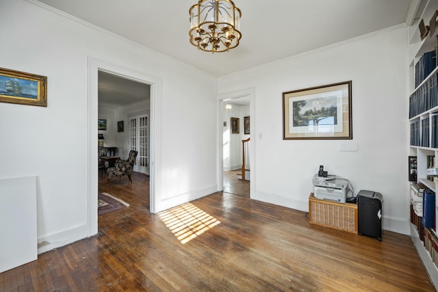 interior space featuring dark wood-style floors, a chandelier, ornamental molding, and baseboards