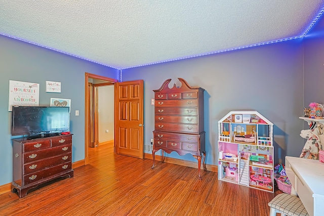 rec room featuring hardwood / wood-style flooring and a textured ceiling