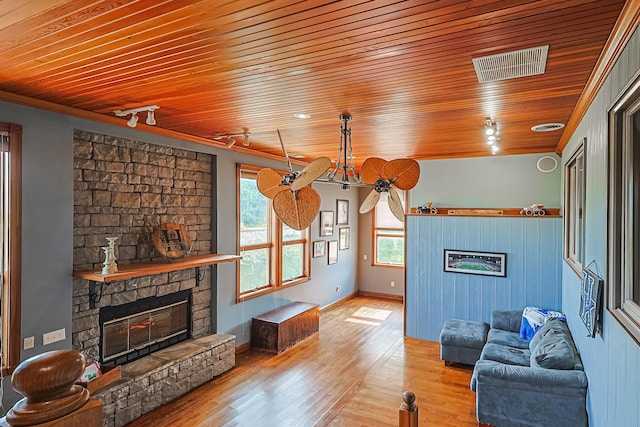 living room with track lighting, wooden ceiling, a fireplace, and light hardwood / wood-style flooring