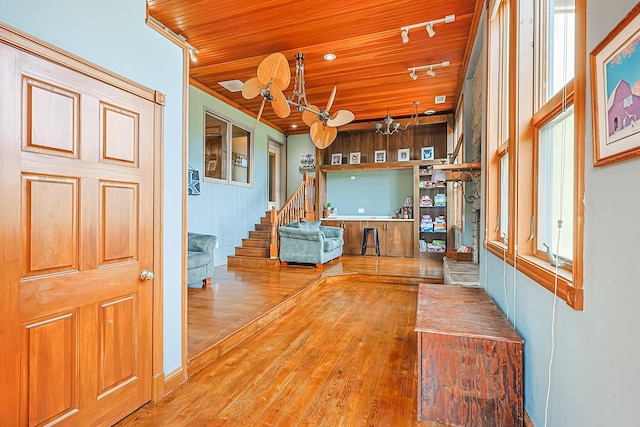 interior space with wood-type flooring, ceiling fan, wood ceiling, a healthy amount of sunlight, and track lighting