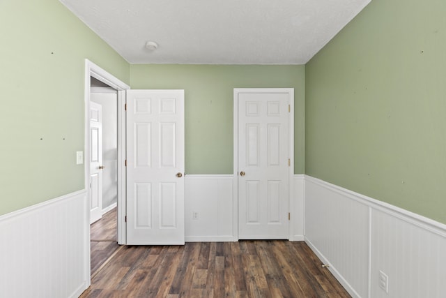 unfurnished bedroom featuring dark hardwood / wood-style floors and a textured ceiling