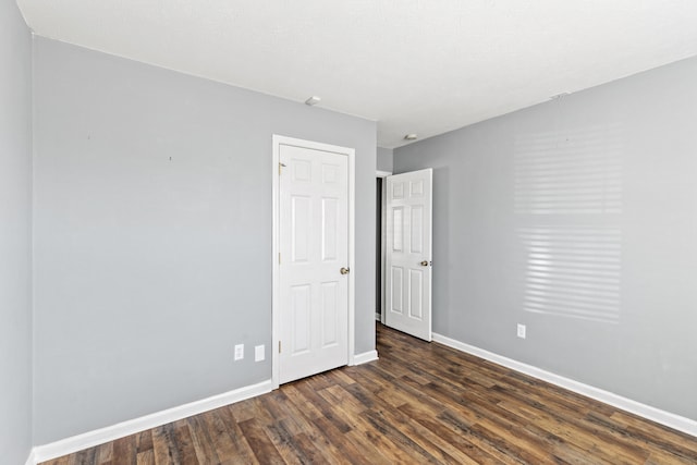 unfurnished room with dark hardwood / wood-style flooring