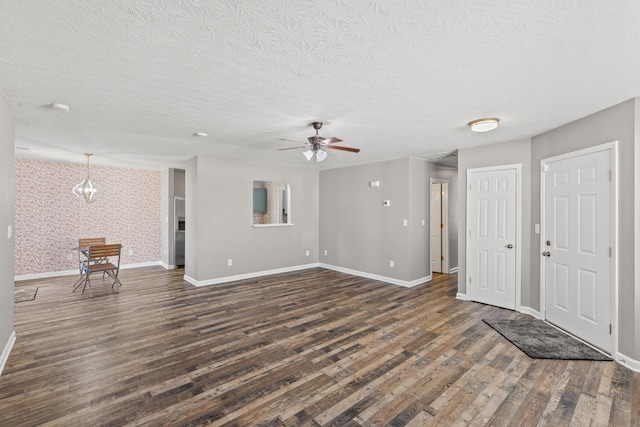 unfurnished living room with dark wood-type flooring, ceiling fan, and a textured ceiling