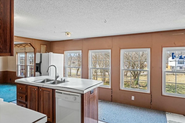 kitchen featuring an island with sink, plenty of natural light, sink, and white dishwasher